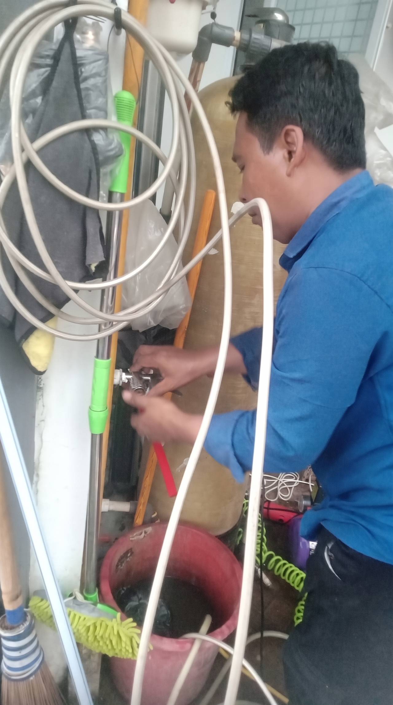 Teknisi memeriksa dan memperbaiki sambungan kran pipa air bersih pelanggan